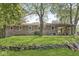 Backyard of the home featuring mature trees, a rock wall, and a partial view of the house at 1710 S Butler Ave, Indianapolis, IN 46203