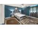 Bedroom with dark teal walls, wood floors and ceiling fan at 1710 S Butler Ave, Indianapolis, IN 46203
