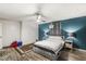 Main bedroom features teal accent wall, wood floors and ceiling fan at 1710 S Butler Ave, Indianapolis, IN 46203