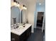 Modern bathroom featuring double sinks, sleek black fixtures, and stylish arched mirrors at 18756 Brookston Ln, Noblesville, IN 46062