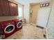 Functional laundry room with ample storage cabinets, tiled floors, and modern washer and dryer units for convenience at 18756 Brookston Ln, Noblesville, IN 46062