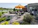 Outdoor patio featuring a fire pit with seating, a yellow umbrella, and view of the pond at 18756 Brookston Ln, Noblesville, IN 46062
