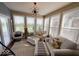 Bright sun room featuring large windows overlooking a serene pond, offering a peaceful retreat with comfortable seating at 18756 Brookston Ln, Noblesville, IN 46062