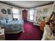Cozy bedroom featuring a metal frame bed, red carpet, and vintage decor at 23 N West St, Shelbyville, IN 46176