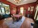 Formal dining room featuring red walls, hardwood floors, chandelier, and vintage furnishings at 23 N West St, Shelbyville, IN 46176