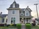 Two-story home with manicured landscaping, charming front porch, and classic architectural details at 23 N West St, Shelbyville, IN 46176