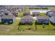 Aerial view of houses with fenced yards, green lawns, a tranquil pond, and community amenities at 2428 S Stonehill Way, New Palestine, IN 46163
