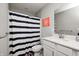 This bathroom has a vanity with white cabinets, quartz countertop, and stylish striped shower curtain at 2428 S Stonehill Way, New Palestine, IN 46163
