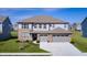 Lovely two-story home with a three-car garage, manicured lawn, and welcoming front porch at 2428 S Stonehill Way, New Palestine, IN 46163