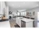 Open kitchen flows into the living room, featuring white cabinets and an island with seating at 2428 S Stonehill Way, New Palestine, IN 46163