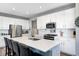 Stylish kitchen boasts white cabinets, stainless steel appliances, and an island with a sink and breakfast bar at 2428 S Stonehill Way, New Palestine, IN 46163