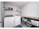 Well-lit laundry room with white appliances, storage shelves, and vinyl flooring at 2428 S Stonehill Way, New Palestine, IN 46163