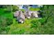 Aerial view of a home with a lush green lawn, mature trees, shed, and an attached garage at 260 17Th St, Columbus, IN 47201