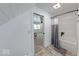 Hallway view to a bathroom with walk-in tub and shower, and bedroom with bed and windows letting in natural light at 260 17Th St, Columbus, IN 47201