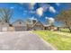 Exterior view showcasing the large driveway, stone chimney, two-car garage, and covered porch area at 260 17Th St, Columbus, IN 47201