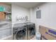 Laundry room featuring newer washer and dryer and wire rack storage with white walls and concrete floors at 260 17Th St, Columbus, IN 47201