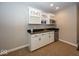 Basement kitchenette with white cabinets, granite counters, and wine rack at 2803 Wild Orchid Way, Columbus, IN 47201