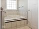 Relaxing whirlpool tub featuring tiled platform and window at 2803 Wild Orchid Way, Columbus, IN 47201