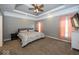 Relaxing main bedroom boasts a tray ceiling, neutral carpet, and soft natural light at 2803 Wild Orchid Way, Columbus, IN 47201