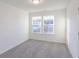 Well lit bedroom with carpet, two windows and white walls at 288 Commodore Dr, Pittsboro, IN 46167