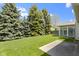 Lush backyard featuring mature trees, a sunroom, and a concrete patio at 3114 Village Park N Dr, Carmel, IN 46033