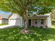 Traditional home showcasing a lush front lawn and mature tree offering shade and curb appeal at 3114 Village Park N Dr, Carmel, IN 46033