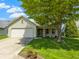 Charming single-story home with a well-manicured lawn, mature tree, and inviting front entrance at 3114 Village Park N Dr, Carmel, IN 46033