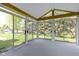 Inviting sunroom with multiple windows and doors providing panoramic views of the green, landscaped yard at 3114 Village Park N Dr, Carmel, IN 46033