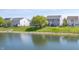 Wide-angle view of the backyard features a pond, grass, weeping willow, fenced yard, and hot tub at 3286 Hemlock St, Whiteland, IN 46184