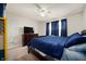 Comfortable bedroom featuring neutral walls, carpet, ceiling fan, and a window with blue curtains at 3286 Hemlock St, Whiteland, IN 46184