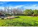 Large backyard featuring mature trees, a playset, and outdoor seating area, perfect for Gathering activities at 360 Hope Ct, Greenwood, IN 46142