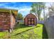 Green backyard featuring the brick side of the house, a small shed, and mature trees at 360 Hope Ct, Greenwood, IN 46142