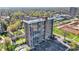 Aerial view shows a high rise condo in a mature treed area, parking, and tennis courts at 4000 N Meridian St # 9E, Indianapolis, IN 46208