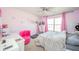 This adorable pink bedroom has a chair and a bed and is decorated with fun artwork and lighting at 403 N Crystal Dr, Fortville, IN 46040