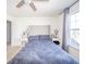 This modern bedroom has a grey headboard and bedspread, a ceiling fan, and white walls at 403 N Crystal Dr, Fortville, IN 46040