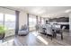 Open-concept dining area features wood floors, large windows, a chair, and a modern table and chairs at 403 N Crystal Dr, Fortville, IN 46040