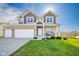 Exterior view of a two-story house with a three-car garage and a well-manicured lawn under a sunny sky at 403 N Crystal Dr, Fortville, IN 46040