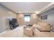 Carpeted living room features a TV and entertainment stand, sofa, lounge chair, and a window at 403 N Crystal Dr, Fortville, IN 46040