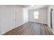 Empty bedroom with dark wood vinyl floors and natural light from one window at 4046 Denali Dr, Indianapolis, IN 46235
