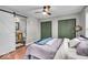 Comfortable bedroom featuring a ceiling fan, hardwood floors, and stylish barn door leading to a private bathroom at 4125 Rookwood Ave, Indianapolis, IN 46208