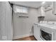 Bright laundry room features modern washer/dryer, wooden floors, ample cabinet space, and a convenient shower at 4125 Rookwood Ave, Indianapolis, IN 46208