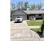 Charming single-story home features a gray brick exterior, well-maintained lawn and a long driveway at 4211 Medina Way, Indianapolis, IN 46227