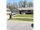 Charming single-story home features a gray brick exterior, well-maintained lawn and a long driveway at 4211 Medina Way, Indianapolis, IN 46227