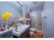 Compact bathroom with a vanity, toilet, and walk-in shower, decorated with artificial flowers at 4411 Rotterdam Dr, Indianapolis, IN 46228