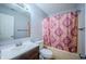 Functional bathroom with a sink, toilet, and bathtub with pink patterned shower curtain at 4411 Rotterdam Dr, Indianapolis, IN 46228
