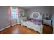 Cozy bedroom featuring white furniture with ornate design, wood flooring and natural light from the window at 4411 Rotterdam Dr, Indianapolis, IN 46228