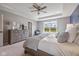 Bright bedroom featuring a window view, tray ceiling, a ceiling fan and neutral colored walls at 5635 Pennycress Dr, Noblesville, IN 46062