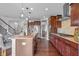 Chef's kitchen featuring a large island, gas cooktop, and dark wood cabinetry at 5635 Pennycress Dr, Noblesville, IN 46062