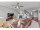 Cozy living room features a fireplace, ceiling fan, and comfortable leather seating, perfect for relaxing and entertaining at 5635 Pennycress Dr, Noblesville, IN 46062