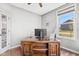 Home office with large window providing ample natural light, features an ornate wooden desk and neutral decor at 5635 Pennycress Dr, Noblesville, IN 46062